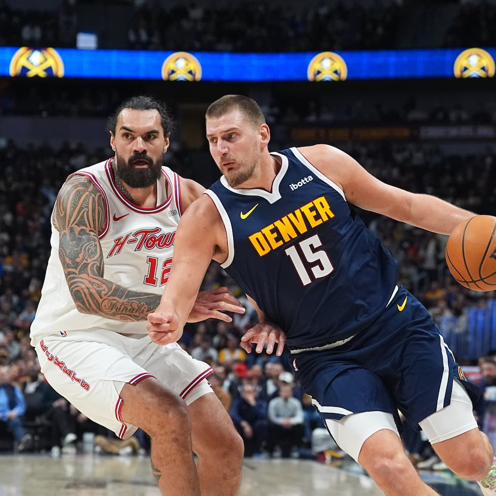 Nikola Jokic, de los Nuggets de Denver, lleva el balón superando a Steven Adams, de los Rockets de Houston.
