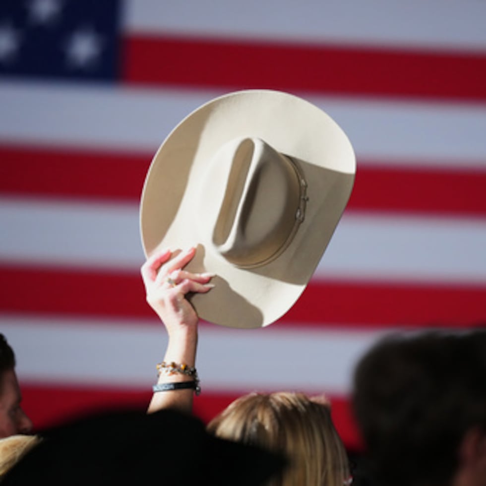 Una persona levanta un sombrero al aire mientras partidarios esperan los resultados de la elección en la que participa el fiscal general de Texas, Ken Paxton.