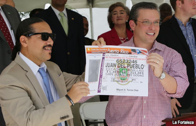 El presidente del Comité Dominicano de Derechos Humanos, José Rodríguez, y el gobernador Alejandro García Padilla celebran la entrada en vigor de la Ley 97 de 2013, que permitió dar licencia de conducir a inmigrantes sin estatus migratorio regularizado.