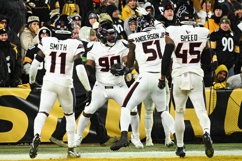 Sheldon Rankins (90), tackle defensivo de los Texans de Houston, celebra con Tremon Smith (11), Will Anderson Jr. (51) y E.J. Speed (45) después de conseguir un touchdown durante la segunda mitad del partido de la ronda de comodines de los playoffs de la NFL en contra de los Steelers.