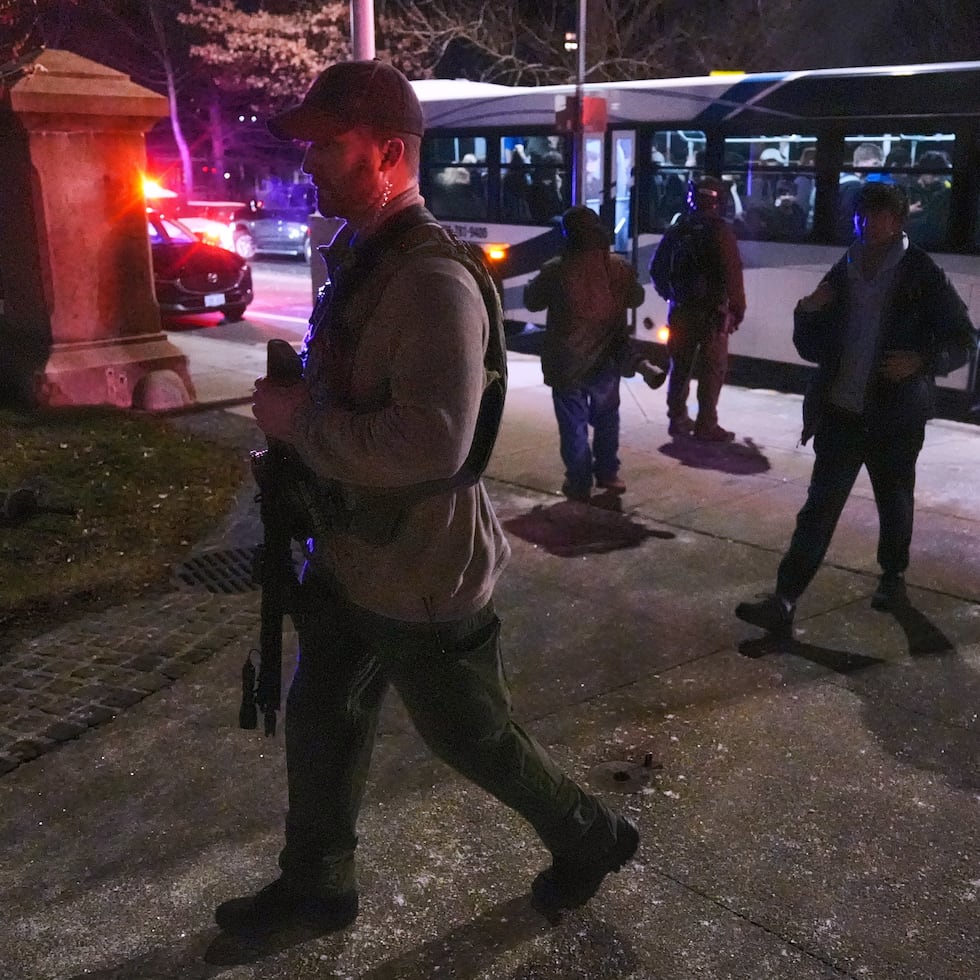 Policías escoltan a estudiantes a refugio seguro tras el ataque en un edificio de la universidad.