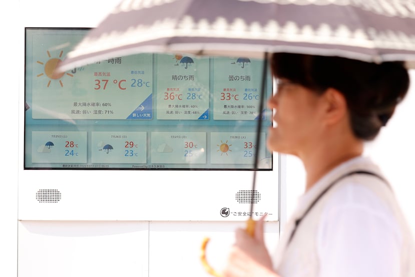 Un peatón sostiene una sombrilla mientras pasa junto a una pantalla que muestra 37 grados Celsius (98 Farenheit), en Tokio, Japón, el 22 de julio de 2026.
EFE/EPA/RODRIGO REYES MARIN