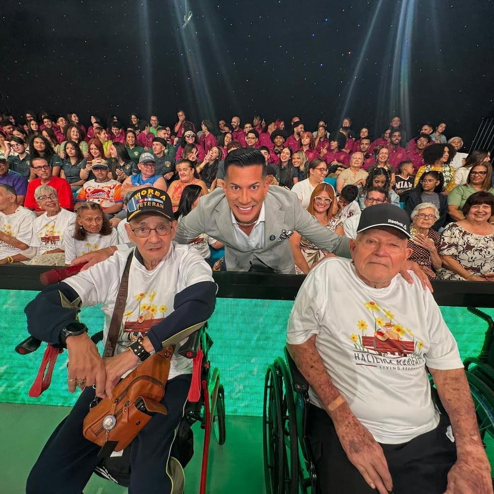 El animador Alex DJ, al centro, junto a dos de los adultos mayores de su hogar en Las Piedras.