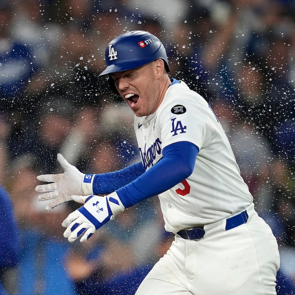 Freddie Freeman es recibido en el plato tras su decisivo cuadrangular.