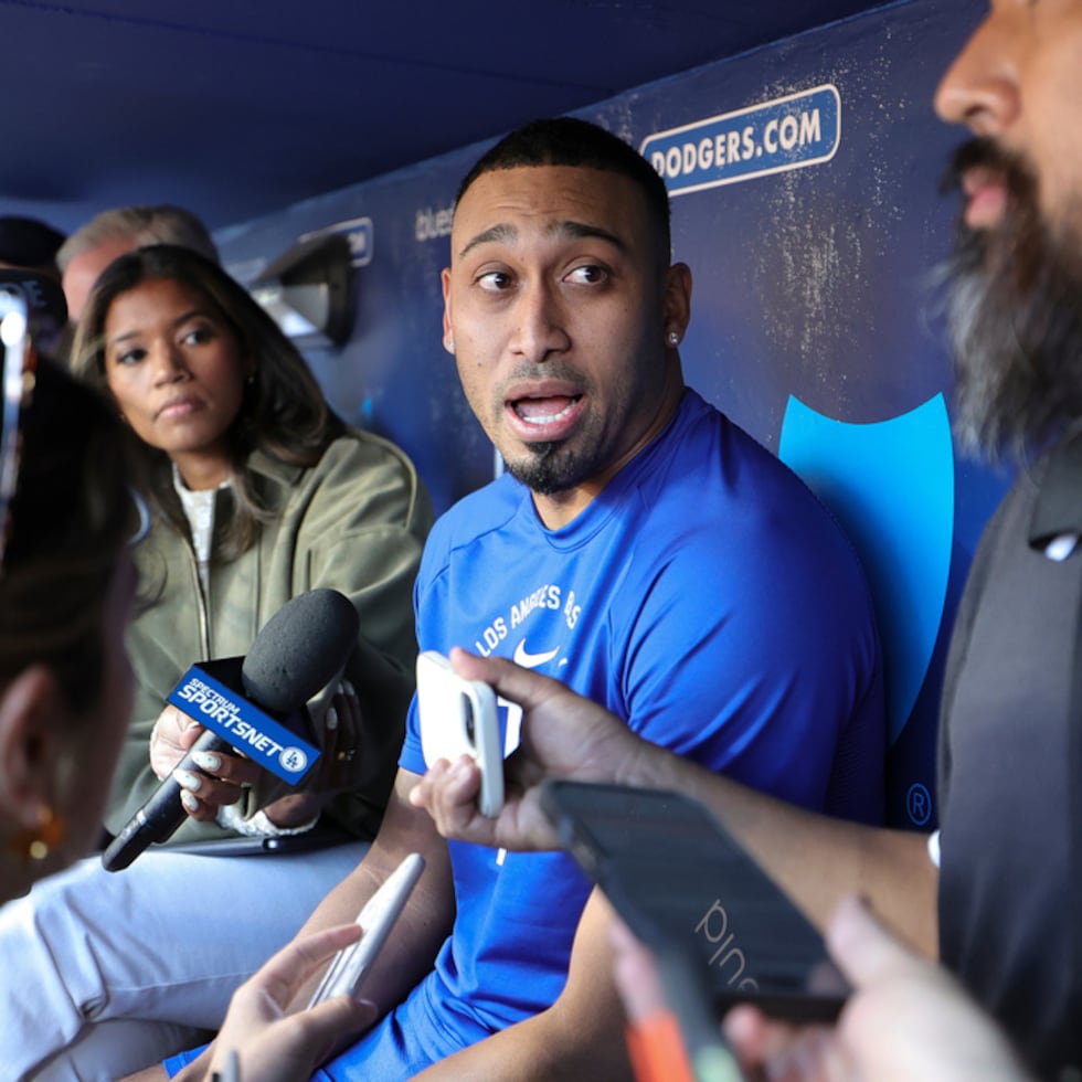 El relevista de los Dodgers de Los Ángeles, Edwin Díaz (centro), concede entrevistas antes de un partido de béisbol contra los Marlins de Miami.