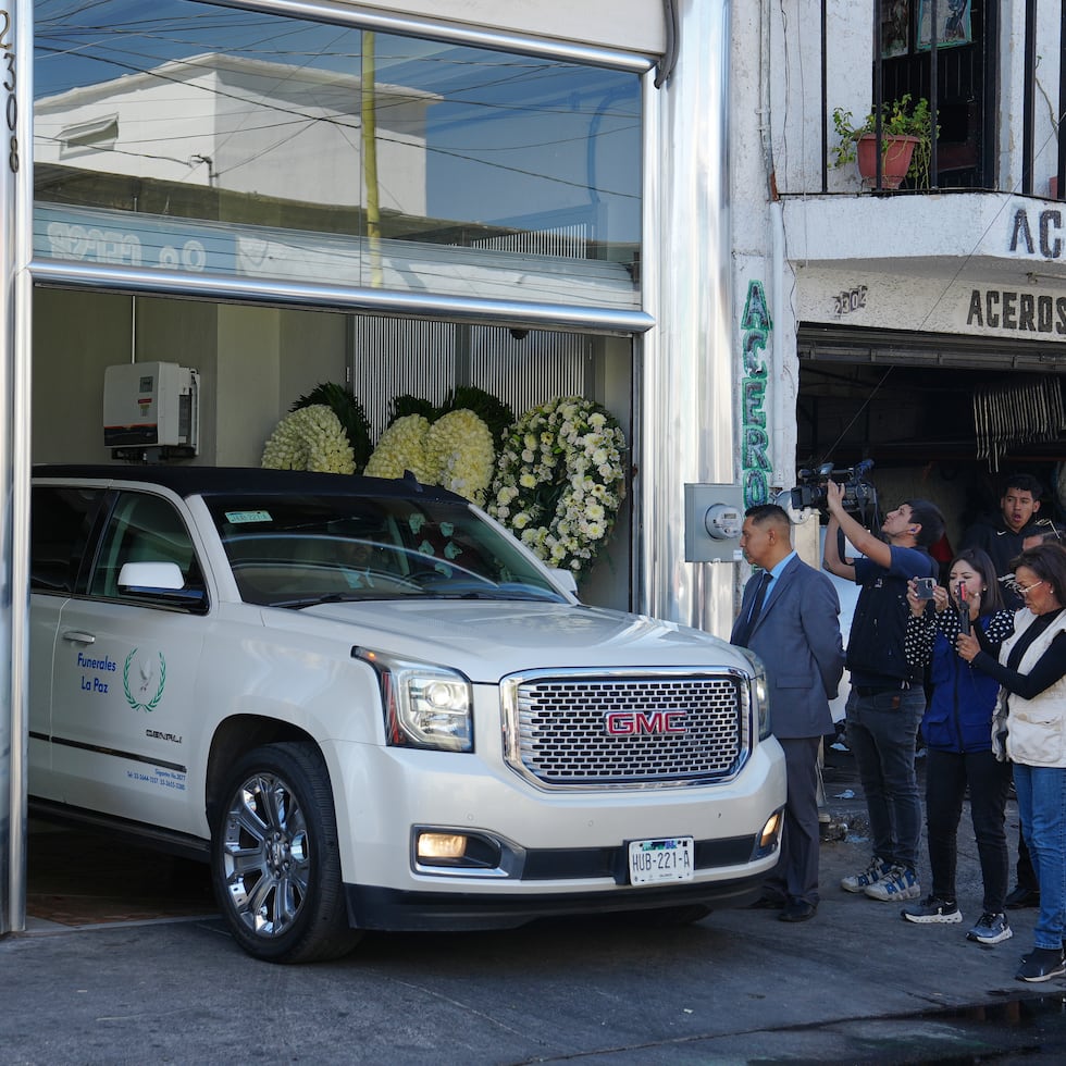 Periodistas toman fotos y videos de un vehículo que transporta los restos de Nemesio Oseguera, alias "El Mencho".