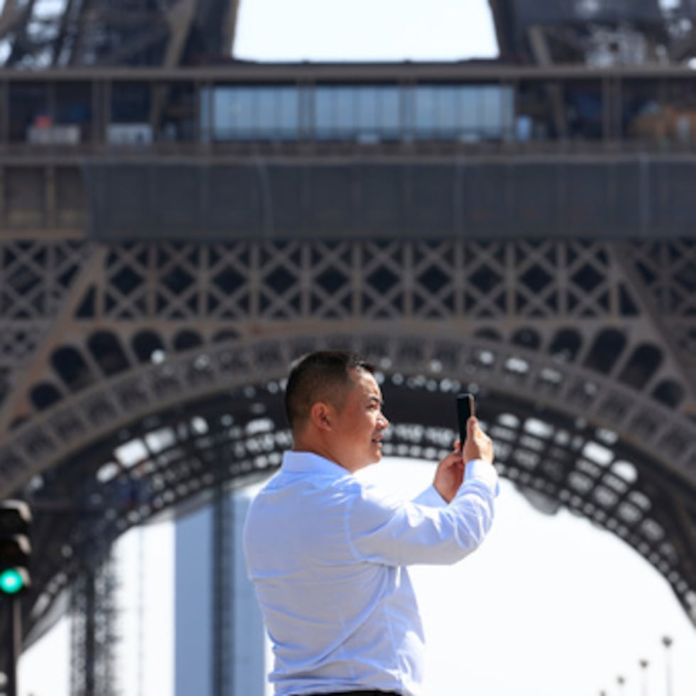 Una persona utiliza su teléfono cerca de la Torre Eiffel en París, el 31 de agosto de 2022. (Foto AP/Aurelien Morissard, archivo)