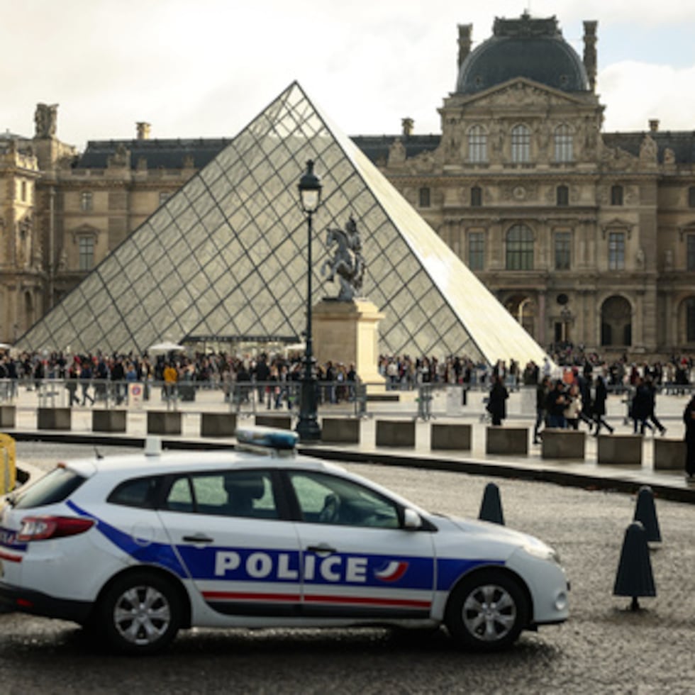 ARCHIVO - Un coche de policía aparca en el patio del museo del Louvre, una semana después del robo, el 26 de octubre de 2025, en París. (AP Photo/Thomas Padilla, Archivo)