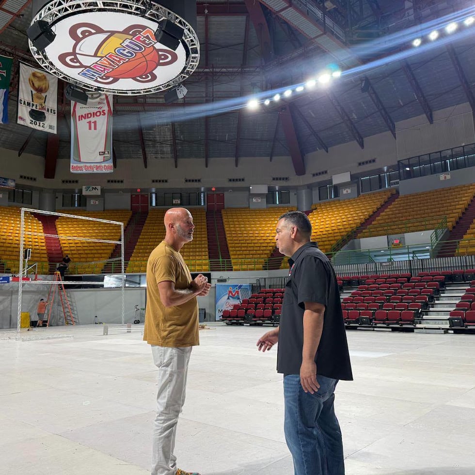 El apoderado Dion New, a la izquierda, conversa con el alcalde de Mayagüez, Jorge Ramos Ruiz, en el Palacio de los Deportes.