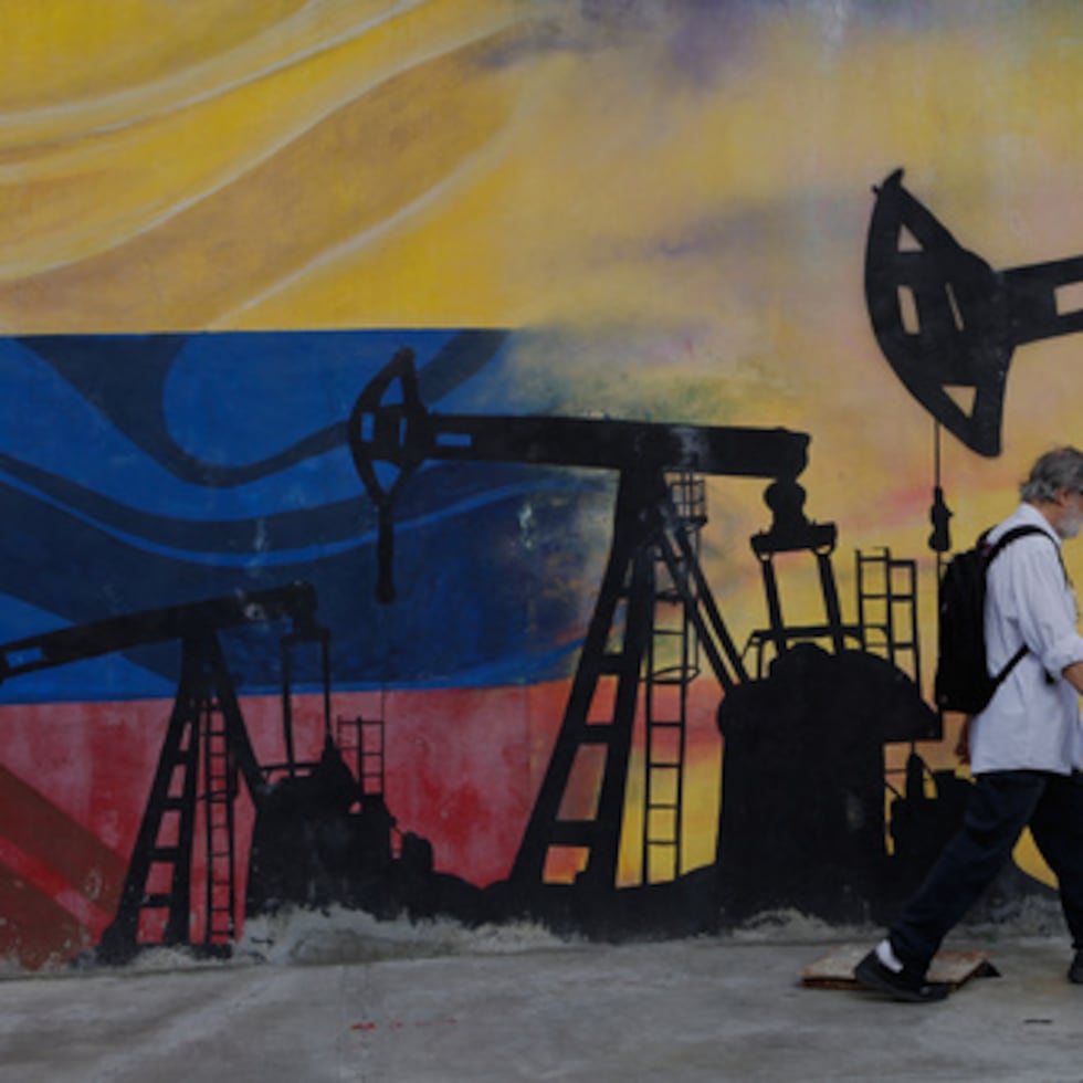 Un peatón pasa junto a un mural en el que se representan pozos de petróleo en Caracas, Venezuela, el sábado 29 de agosto de 2026, un día después de que el presidente Donald Trump anunciara un acuerdo que otorga a Estados Unidos una participación en las reservas petroleras de Venezuela.