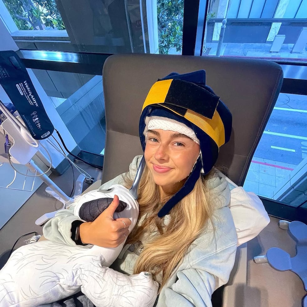 Fotografía tomada de la cuenta de Instagram @SydneyTowle, de la creadora de TikTok estadounidense Sydney Towle, donde aparece durante una sesión de quimioterapia después de ser diagnosticada a los 23 años con colangiocarcinoma, un cáncer poco frecuente y agresivo.