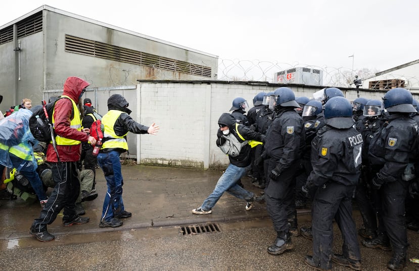Agentes de policía se sitúan cerca del salón de actos e impiden el acceso a los manifestantes durante una protesta contra la fundación de una nueva organización juvenil de la AfD, en Hesse, Alemania, el sábado 29 de noviembre de 2025. (Boris Roessler/dpa vía AP)