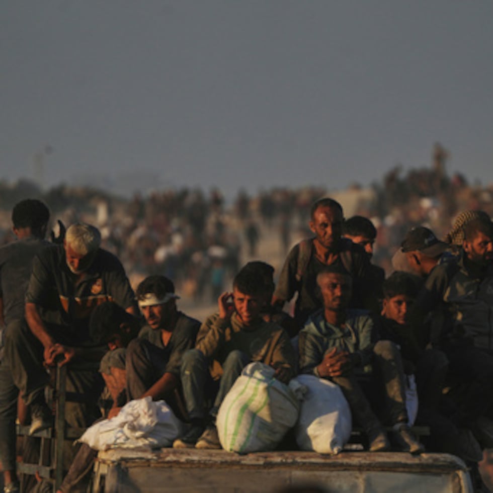 Palestinos transportan sacos de harina descargados de un convoy de ayuda humanitaria que llegó a la ciudad de Gaza desde el norte de la Franja de Gaza, el domingo 24 de agosto de 2025.