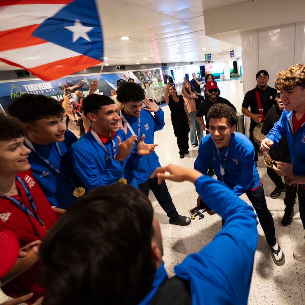 Jugadores de la Selección Nacional Sub-17 de voleibol masculino festejan a su llegada al Aeropuerto Luis Muñoz Marín.