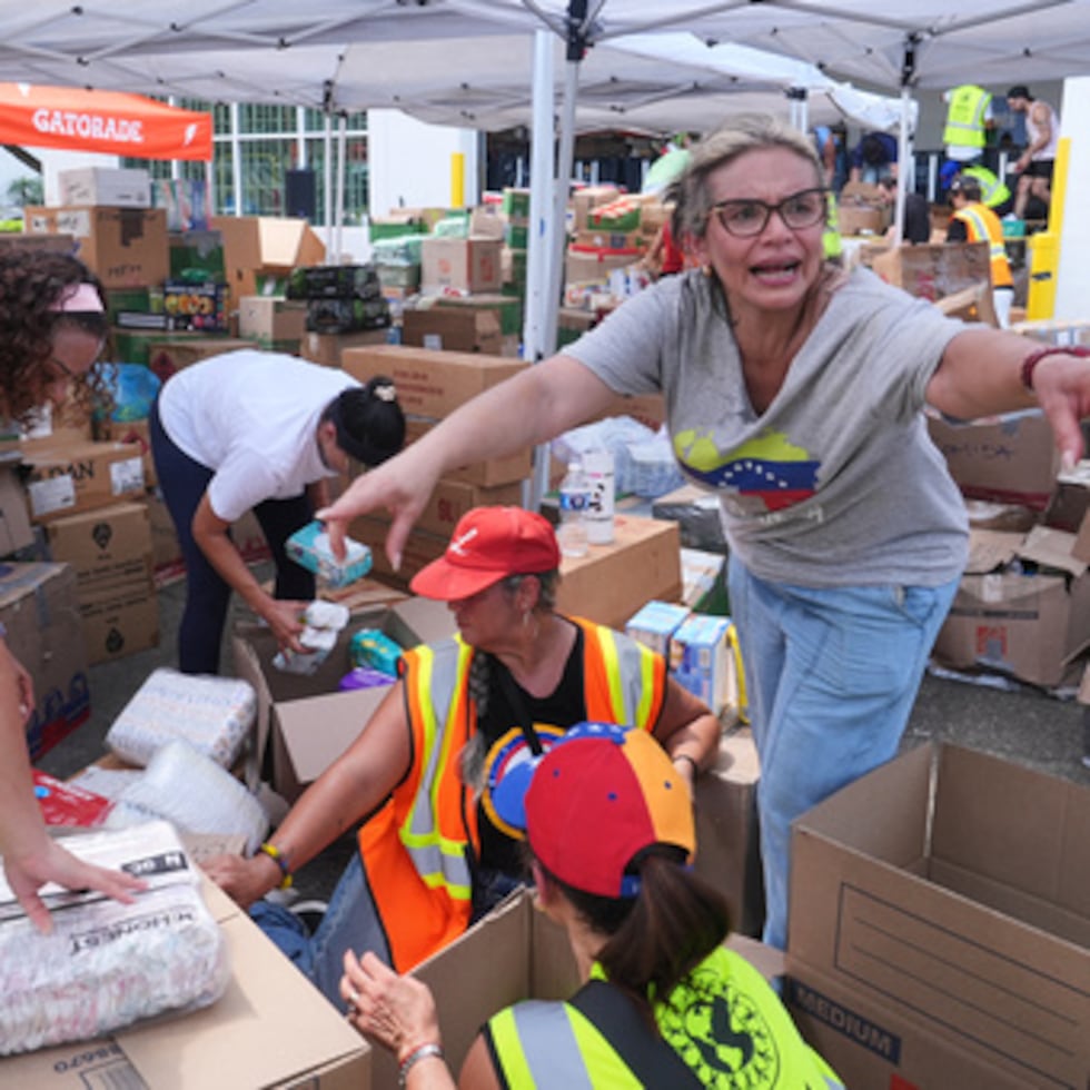 Lisa Galindez anima a otros voluntarios a ayudar a empaquetar artículos para bebés en el centro de donaciones de ayuda humanitaria de Global Empowerment Mission Venezuela.