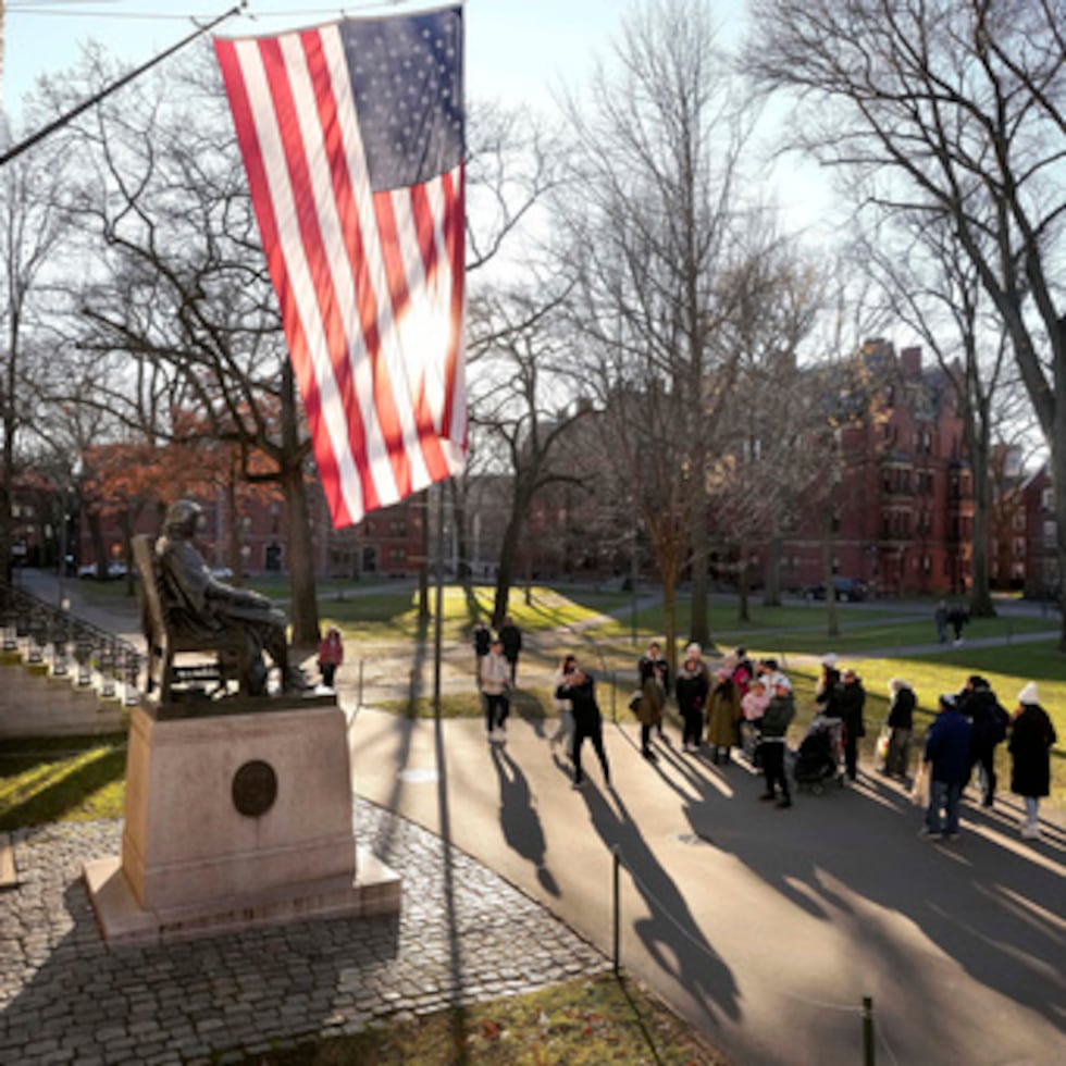 Visitantes en Harvard admiran estatua de John Harvard.