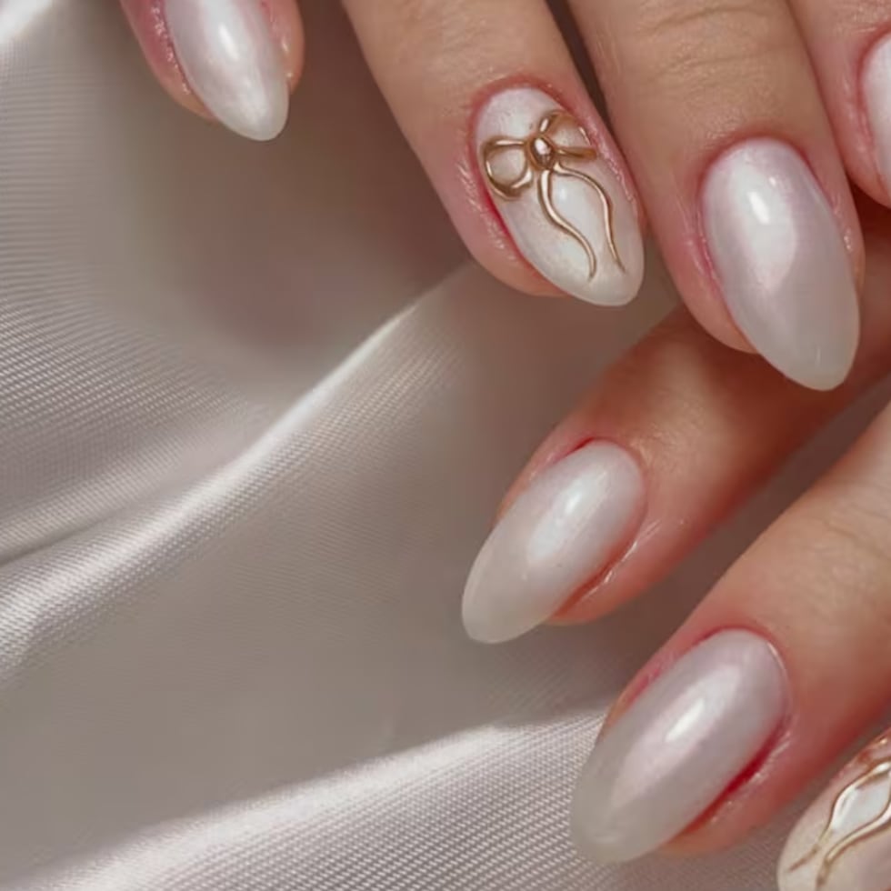 En tonos cremosos ultra suaves, opta por un diseño con figuras sutiles, como flores o lazos, sobre una base nude brillante. El toque "Cloud Dancer" aparece en los detalles blancos que se ven casi esculpidos sobre la uña, creando un efecto discreto y muy femenino