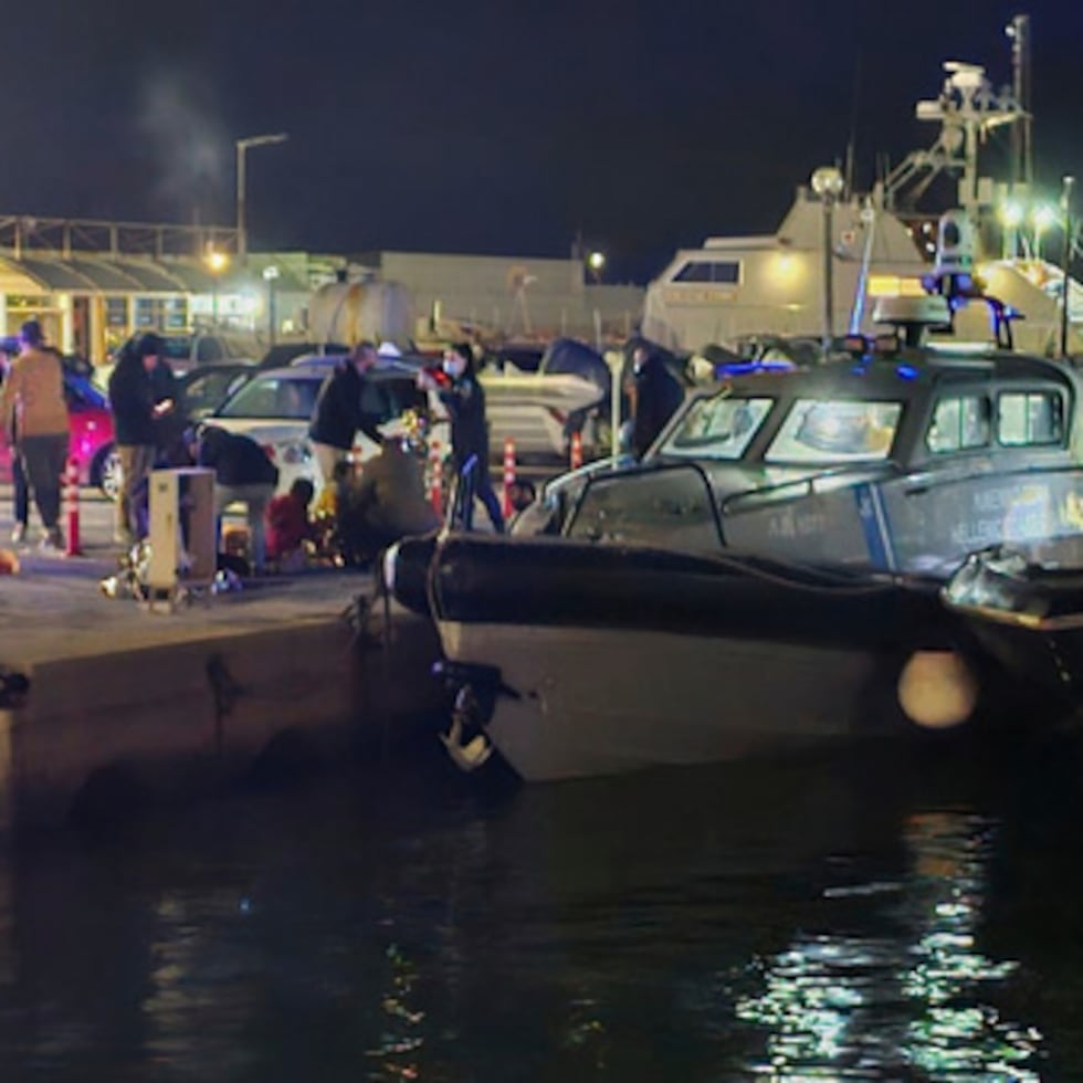 Agentes de la guardia costera griega llevan a cabo operaciones de rescate en un puerto de la isla griega de Quíos, tras la colisión entre una lancha motora de inmigrantes y una patrullera de la guardia costera.