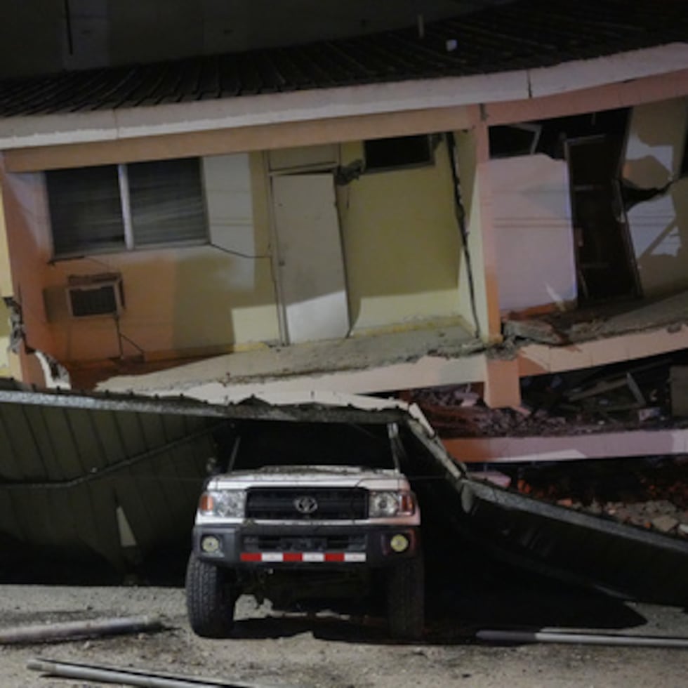 Un vehículo yace aplastado bajo un edificio derrumbado tras el terremoto que sacudió Penónome, Panamá.