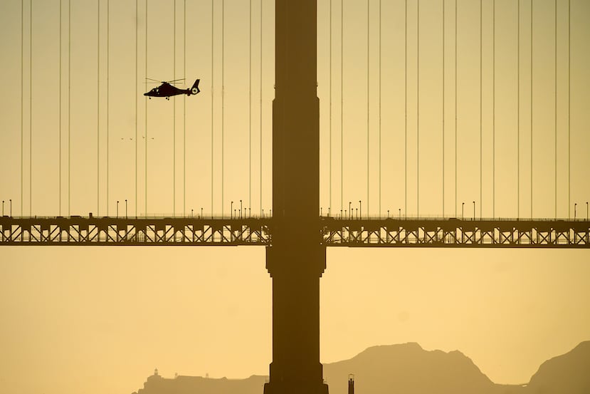 Un helicóptero sobrevuela el puente Golden Gate en busca de las víctimas desaparecidas tras un accidente náutico cerca de la isla de Alcatraz, frente a San Francisco, el martes 14 de julio de 2026. (Foto AP/Noah Berger)