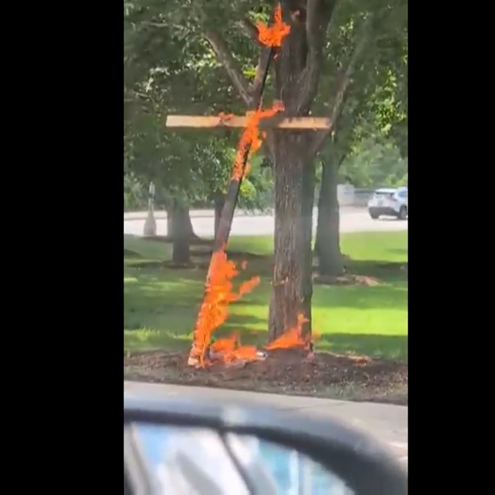 Esta escena de un video tomada por la conductora Keinika Carlton muestra una cruz de madera envuelta en llamas naranjas, apoyada sobre un árbol en Grant Park, Chicago, Illinois.