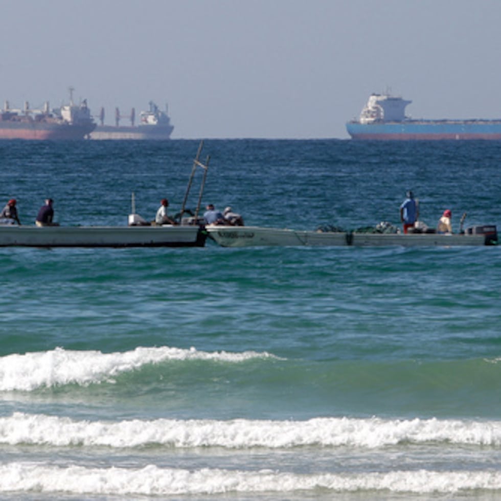Pescadores trabajan ante un petrolero en el sur del estrecho de Ormuz ante la costa de la localidad de Ras Al Khaimah en Emiratos Árabes Unidos.