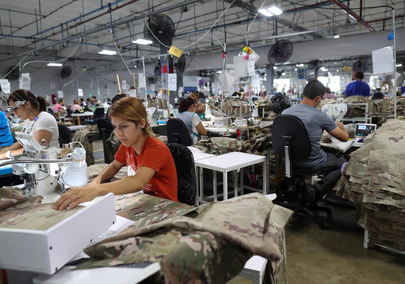 Anelis Jiménez (camisa roja) y otros empleados en la fábrica de SNC Technical Services, en Camuy.