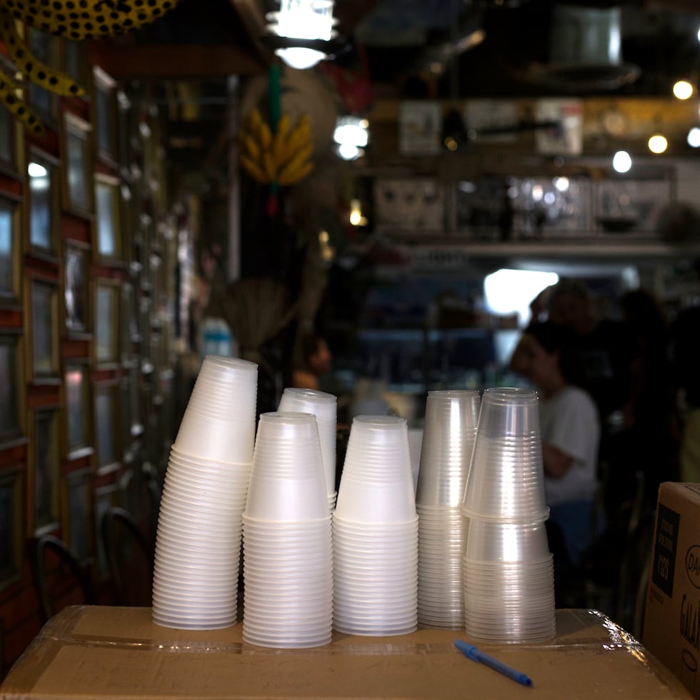 Fotografía de archivo de vasos de plástico de un solo uso en la barra de un bar.\