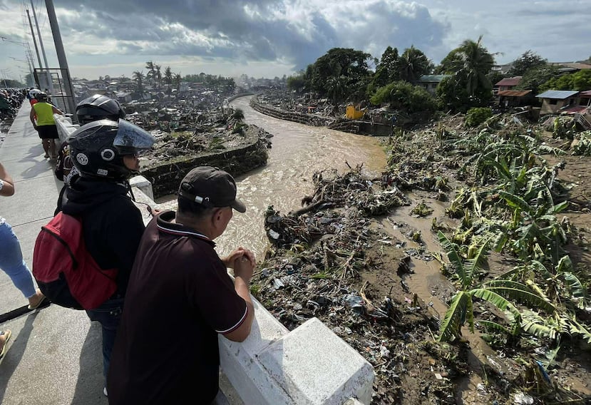 Varios hombres observan las casas dañadas tras la devastación causada por el tifón Kalmaegi en las comunidades a lo largo del río Mananga en la ciudad de Talisay, provincia de Cebú, en el centro de Filipinas.