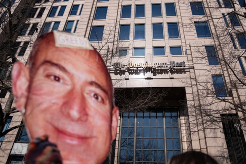 Un manifestante sostiene un recorte de la cara de Jeff Bezos fuera de la oficina del Washington Post tras un despido masivo, el jueves 5 de febrero de 2026, en Washington. (AP Photo/Allison Robbert)