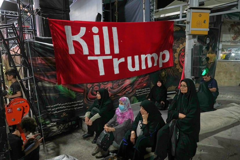 Varias mujeres se sientan junto a una pancarta que dice en inglés "Maten a Trump" durante una manifestación progubernamental, el viernes 17 de julio de 2026, en Teherán, Irán. (AP Foto/Vahid Salemi)