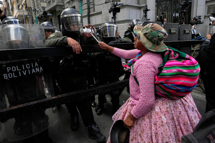 Una manifestante apunta con su cucharón a los policías que montan guardia cerca del palacio de gobierno durante una protesta antigubernamental en La Paz, Bolivia, el miércoles 27 de mayo de 2026. (Foto AP/Juan Karita)