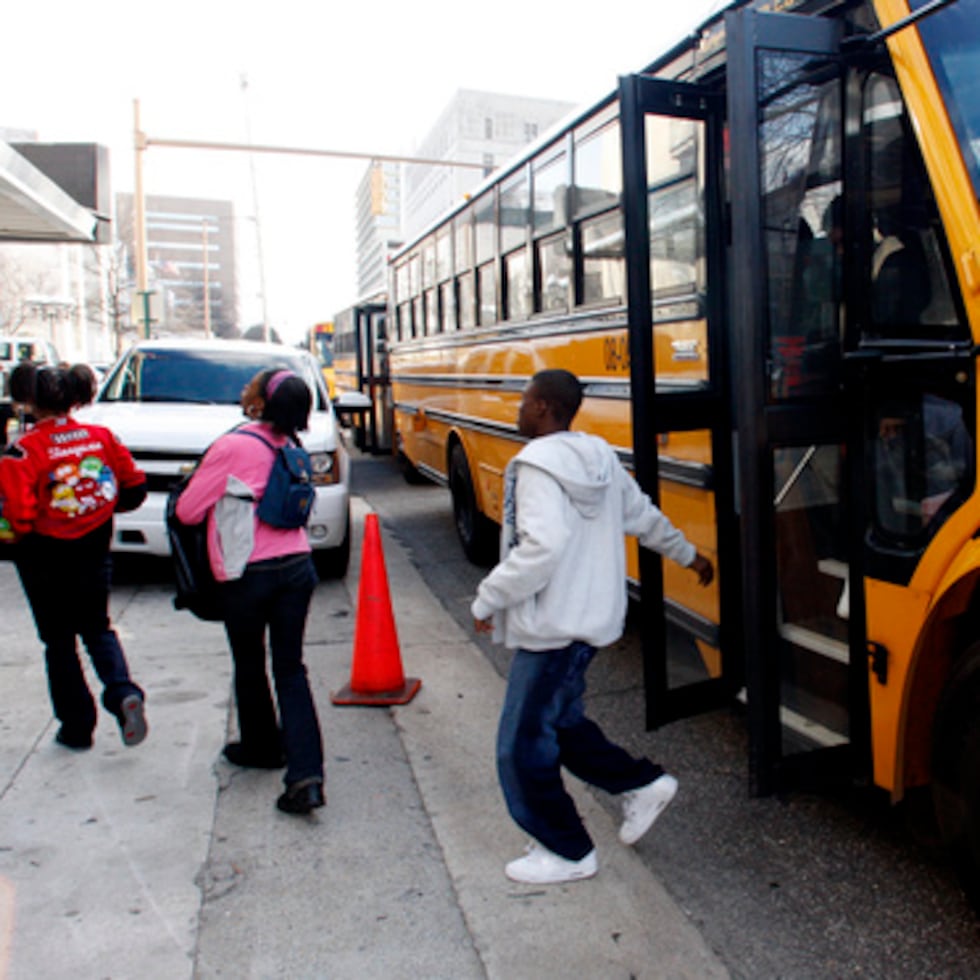 Estudiantes de Ossie Wera Mitchell Middle School bajan del autobús escolar.