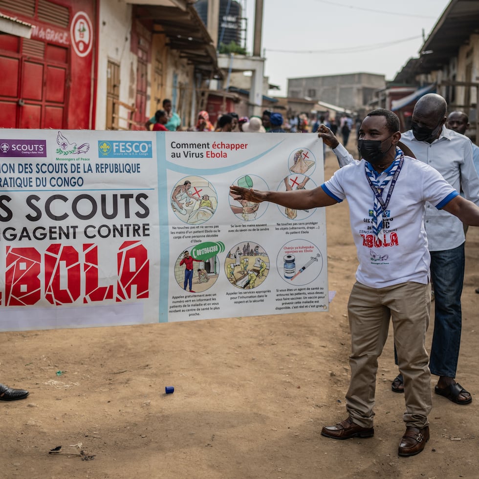 Miembros del movimiento de Scouts del Congo muestran una pancarta de concientización sobre el ébola en una calle durante una campaña de sensibilización del público en medio del brote de la enfermedad.