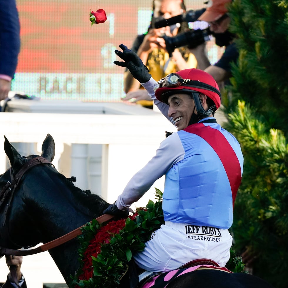 John Velazquez riding Medina Spirit throws a rose after his victory in the 147th running of the Kentucky Derby at Churchill Downs, Saturday, May 1, 2021.