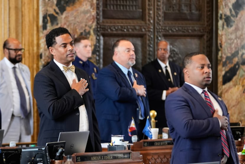 Louisiana Reps. Adrian Fisher, D-Dist 16, izquierda, Chad Michael Boyer, R-Dist 46, y C. Travis Johnson, D-Dist 21, derecha, recitan el juramento de lealtad antes de una votación de la Cámara sobre un plan de redistribución de distritos para eliminar un distrito del Congreso de mayoría negra en respuesta a un fallo de la Corte Suprema de EE.UU., en Baton Rouge, La., Jueves, 21 de mayo 2026. (AP Photo/Gerald Herbert)