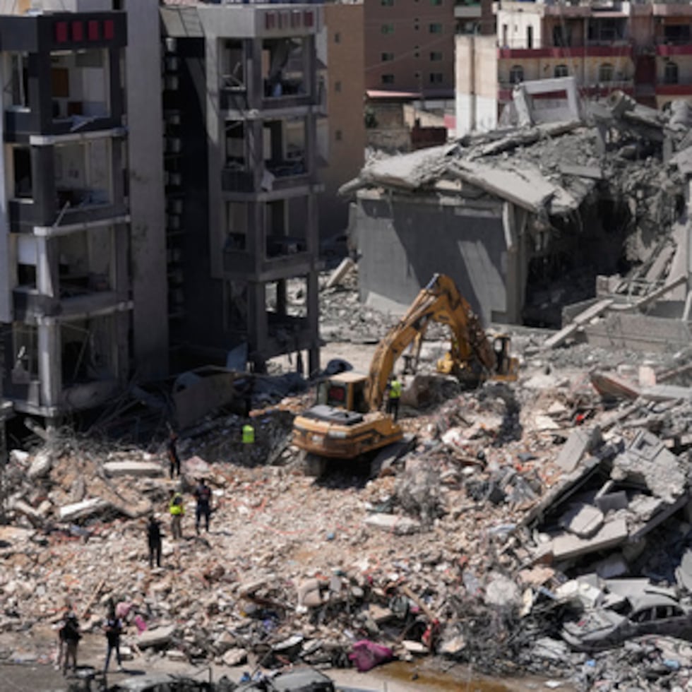 Los trabajadores de rescate utilizan una excavadora, mientras buscan víctimas bajo los escombros de un edificio que fue alcanzado el lunes en un ataque aéreo israelí en el sur de la ciudad portuaria de Tiro, Líbano, martes, 2 de junio de 2026. (AP Photo/Mohammed Zaatari)