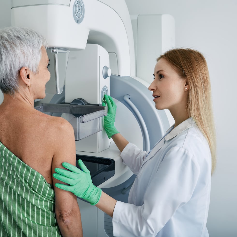 Senior woman having mammography scan at hospital with medical technician. Mammography procedure, breast cancer prevention