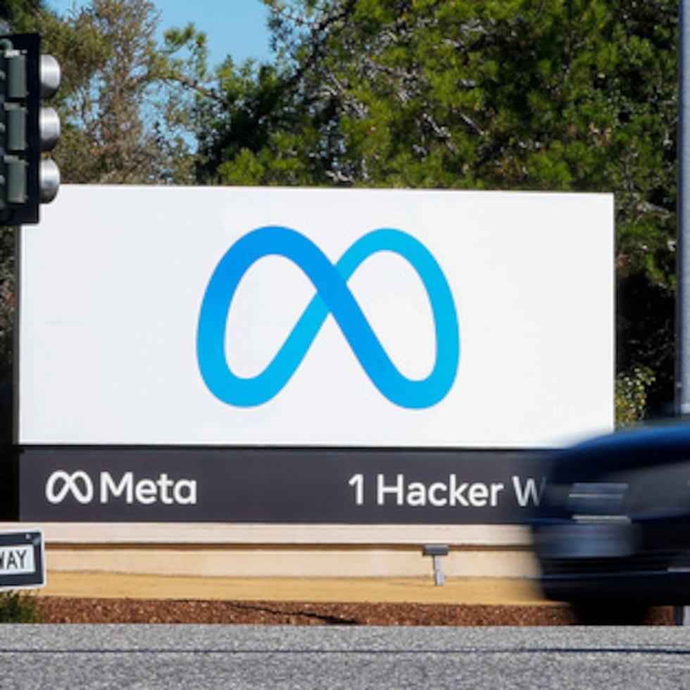 Un coche pasa frente al nuevo logotipo de Meta en California.