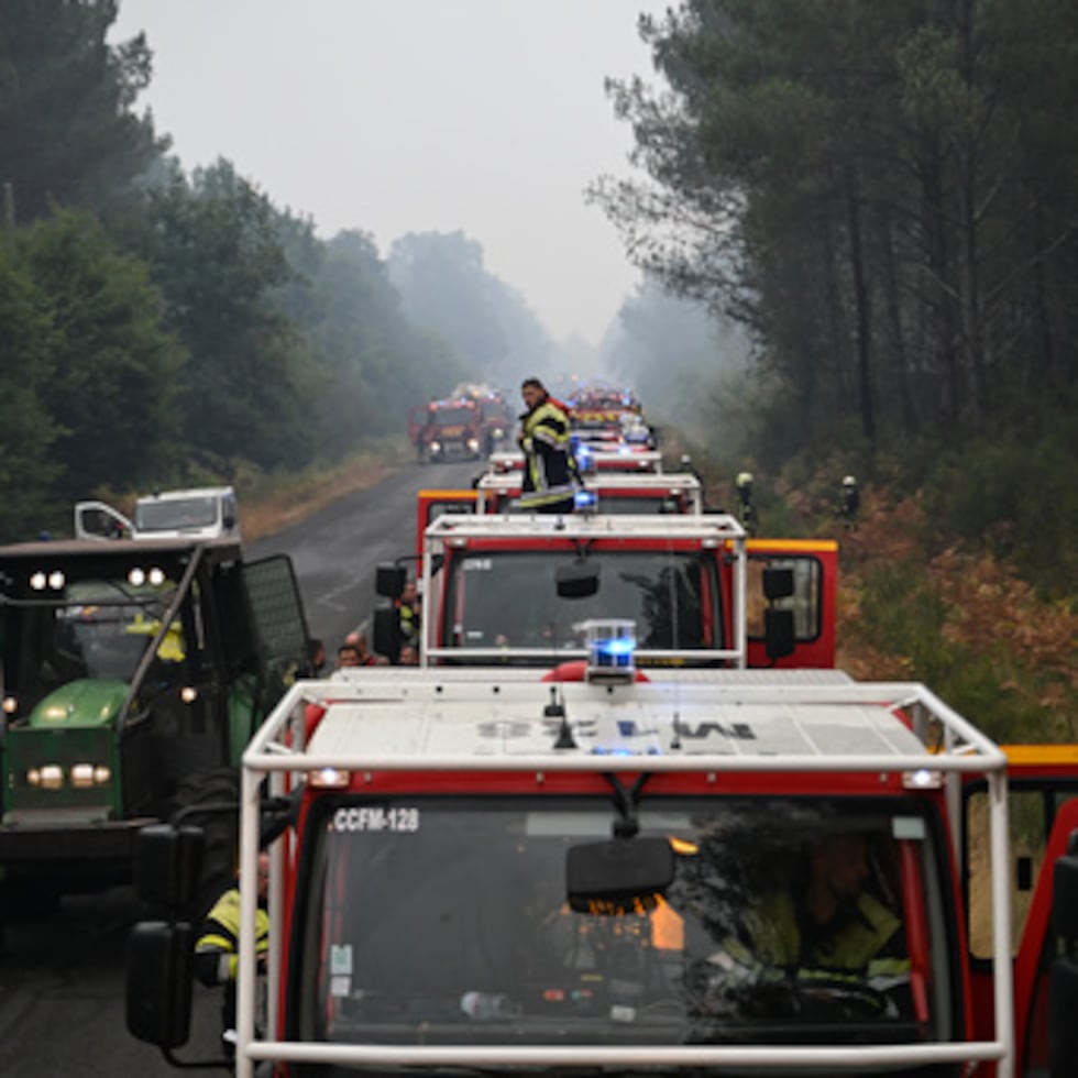 Un bombero se encuentra de pie sobre un camión en una carretera cerca de Lacanau, en el suroeste de Francia, mientras los incendios forestales arrasan la zona.