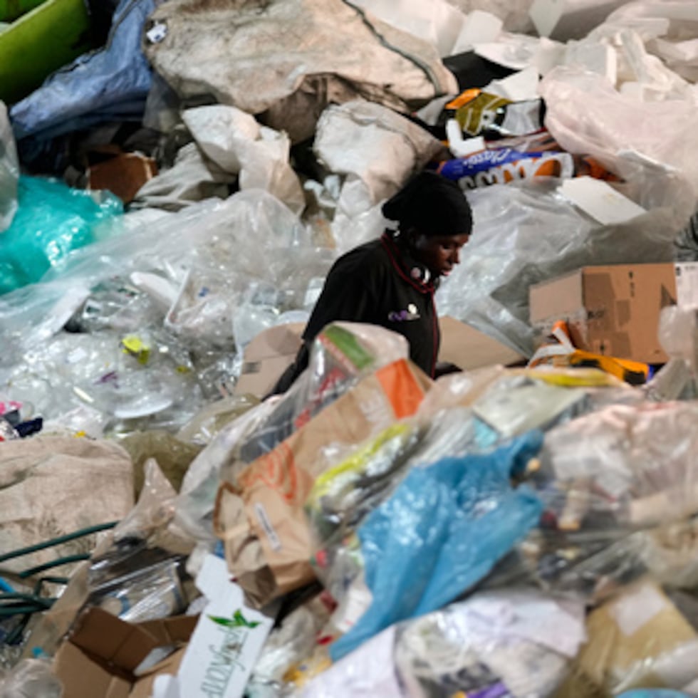 Un trabajador clasifica materiales reciclables en un montón de basura en las instalaciones de Whole Earth Recycling, en Johannesburgo.