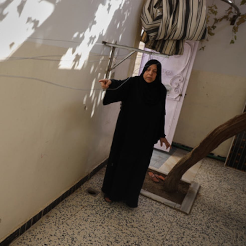 Sabah al-Sheikh al-Kilani, madre de Khaled al-Masoud, señala los agujeros de bala en la pared de la casa de su hijo tras ser asesinado durante un asalto en la localidad de al-Dumayr, en la campiña de Damasco, Siria, 28 de octubre de 2025. (AP Photo/Omar Albam)