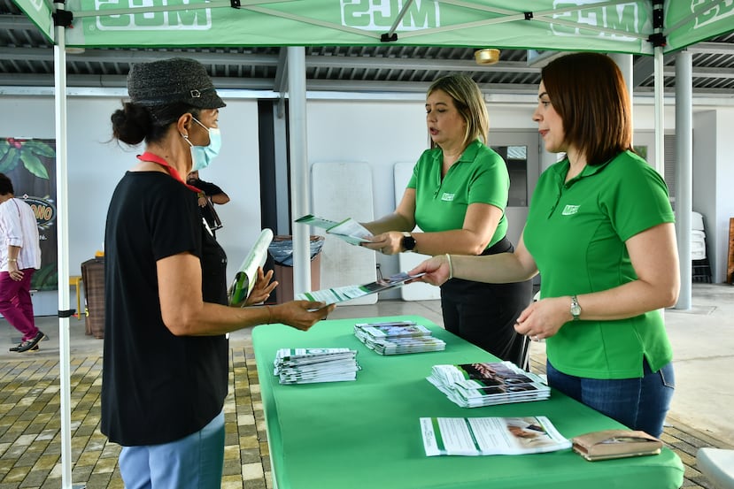 Participante de actividad del MCS Club Te Paga siendo orientada por representantes de servicio de MCS.