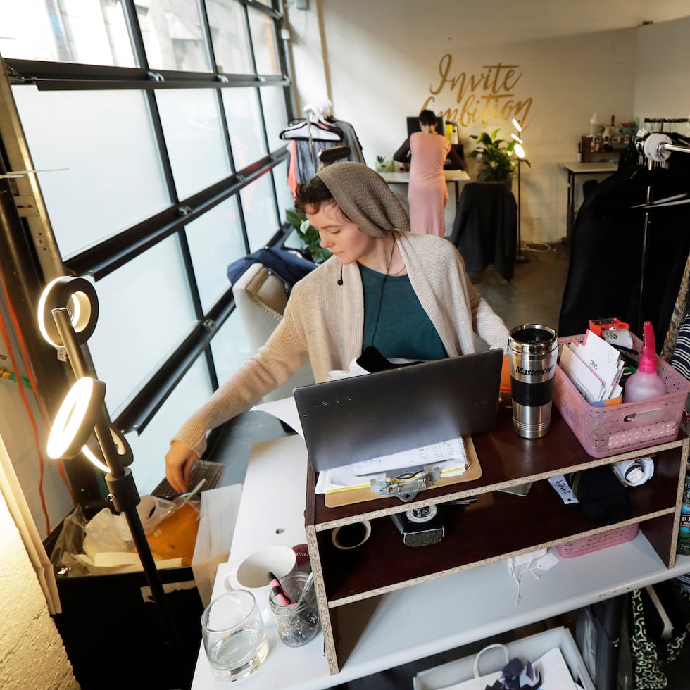 Madeline Smith empaca ropa para su envío mientras trabaja para Armoire, una empresa de alquiler de ropa con sede en The Riveter, un espacio de trabajo compartido dirigido a mujeres en Seattle.