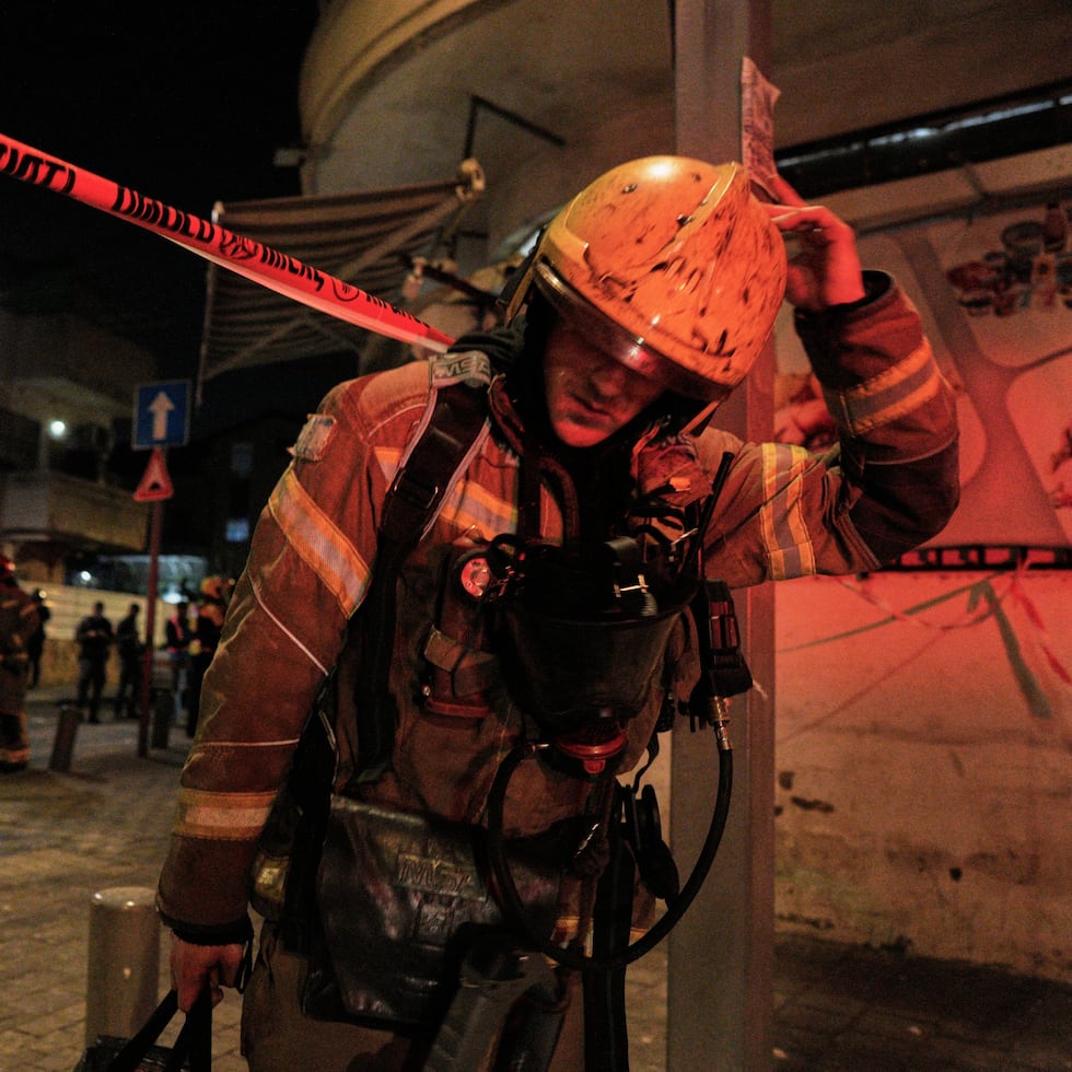 Un efectivo de los servicios de emergencia de Israel abandona el lugar donde impactó un misil en Tel Aviv, Israel.