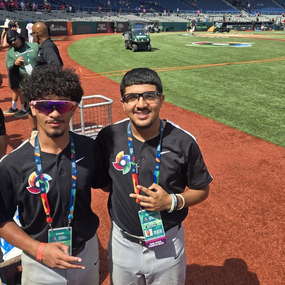Ángel Ruiz (izquierda) y Carlos Morales, de la Puerto Rico Baseball Academy, posan desde sus posiciones en el Estadio Hiram Bithorn durante sus funciones como 'bat boys' en el Clásico Mundial de Béisbol.