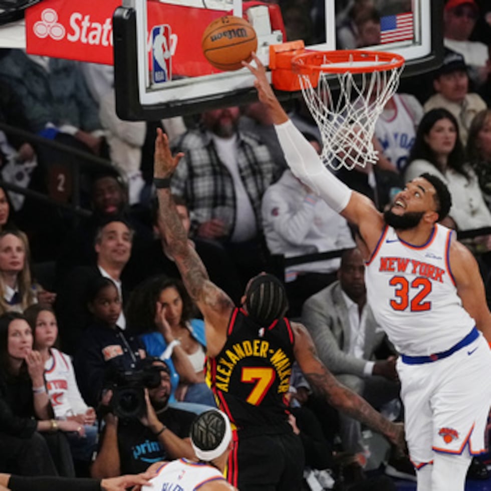 Karl-Anthony Towns (32), de los New York Knicks, bloquea un tiro de Nickeil Alexander-Walker (7), de los Atlanta Hawks, durante la primera mitad del primer partido de la primera ronda de los playoffs de baloncesto de la NBA, el sábado 18 de abril de 2026, en Nueva York. (Foto AP/Frank Franklin II)