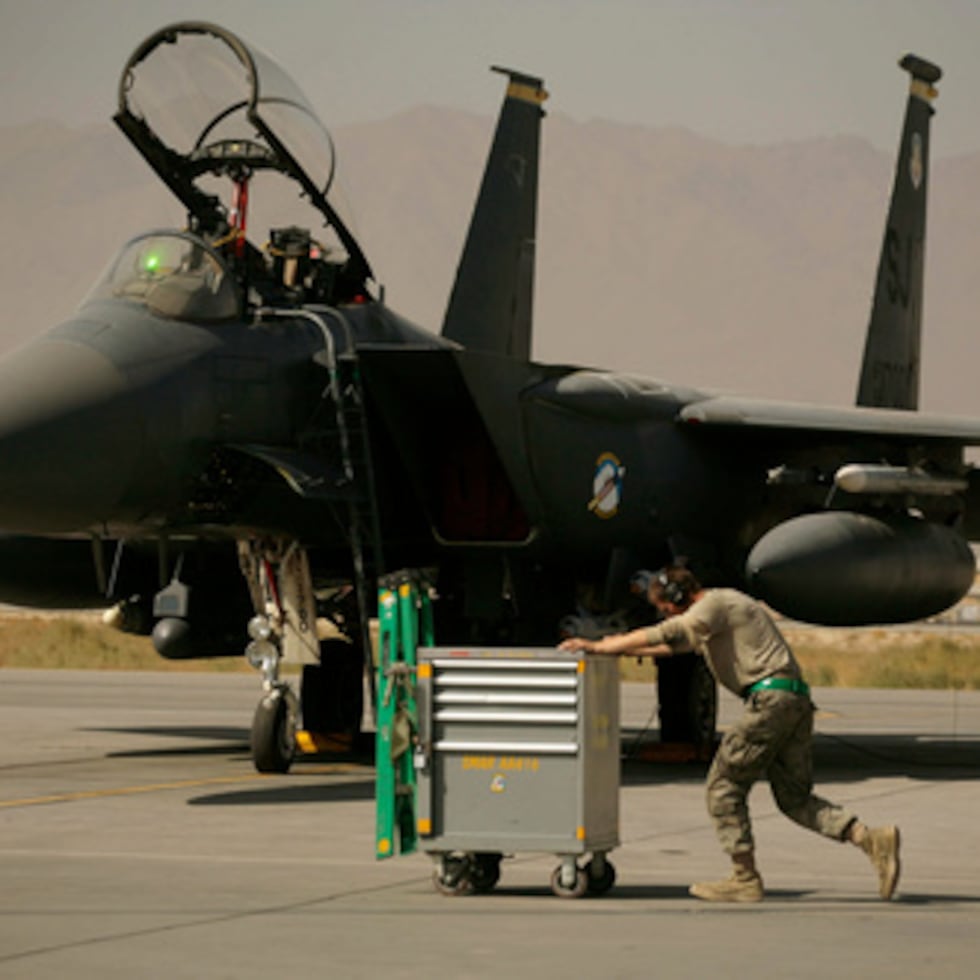 Un aviador de las Fuerzas Aéreas estadounidenses empuja un carro junto a un F-15E Strike Eagle en el campo aéreo de Bagram, Afganistán.