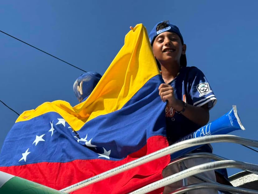 Un miembro del equipo venezolano celebrando el triunfo con la bandera de su país.