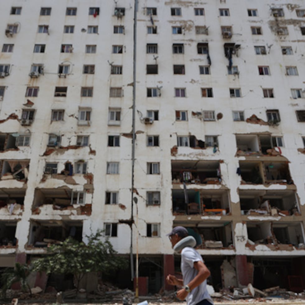 Un vecino pasa junto a un edificio dañado un día después de que un terremoto y varias réplicas sacudieran La Guaira, Venezuela.